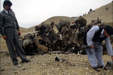 r : Security personnel survey the site of a suicide car bomb blast in Khost province March 21, 2009. A roadside bomb struck a passing car in the southeastern province of Khost,