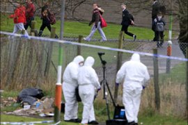 afp ; Children walk past police forensic officers working near the crime scene in which a policeman was killed late Monday night in Craigavon, Northern Ireland, on March 10, 2009. A