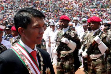 afp : Andry Rajoelina (L) walks past a guard of honour during a ceremony in Antananarivo's stadium where he was officially invested as transitional president of Madagasar on