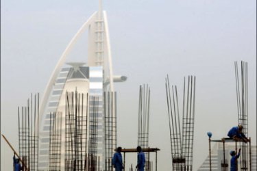 afp : Foreign labourers work at a construction site in front of Dubai's landmark Burj al-Arab hotel on March 22, 2009. The economy of the United Arab Emirates might contract this