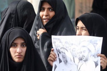 afp/ Bahraini Shiite women hold a picture of Hassan Mesheima (L), head of the Shiite-dominated opposition Haq movement, and Shiite cleric Mohammed al-Moqdad (R) as they wait for their release in the northern city of Jidhafs on April 12, 2009