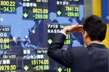 A man watches a board showing current stock indexes of some countries outside a brokerage in Tokyo April 21, 2009