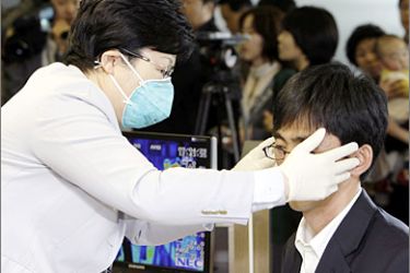 REUTERS/ A South Korean quarantine officer checks the body temperature of a passenger arriving from China at Incheon International Airport April 28, 2009. A new virus has killed up to 149 people in Mexico and the World Health Organization moved closer on Monday to declaring it the first flu pandemic