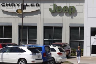 A man peers into the permanently closed Bankston Chrysler, Jeep, Dodge Car Dealership in Frisco,
