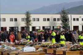 Relative gather in the vast square courtyard of a "Guardia di Finanzia" police training centre where some 200 coffins were arrayed on April 10, 2009 pior the state funeral of the dead