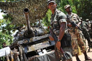 afp/Sri Lankan soldiers stand guard next to a tank which was captured by the army from the Liberation Tigers of Tamil Eelam (LTTE) in Kilinochchi during a weapons display organized by the army on April 24, 2009.
