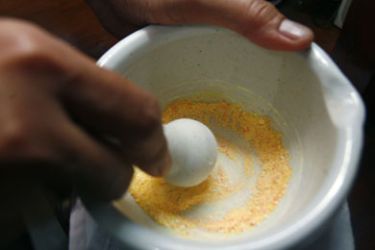 A doctor crushes different drugs into powder in a bowl in Jakarta March 29, 2009. Experts warn that driven by profits from selling medicine, some doctors from Indonesia to Hong