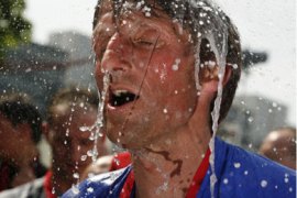 R/ A participant takes a refreshing shower after finishing the Hamburg Marathon run in Hamburg April 26, 2009. About 20,000 runners, skaters, wheelchair athletes and hand-bikes from 85 nations took part in the annual marathon around Hamburg's city centre