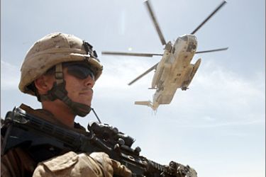 REUTERS / A U.S Marine stands guard as a U.S Marine helicopter prepares to land near a military base in the Golestan district of Farah province, April 29, 2009. REUTERS/Goran Tomasevic (AFGHANISTAN CONFLICT MILITARY TRANSPORT)