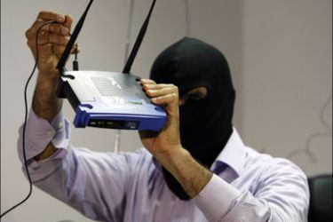 afp ; A masked Lebanese secret service officer shows to the media at the Lebanese security services headquarters in Beirut on May 11, 2009 a wireless internet router found with