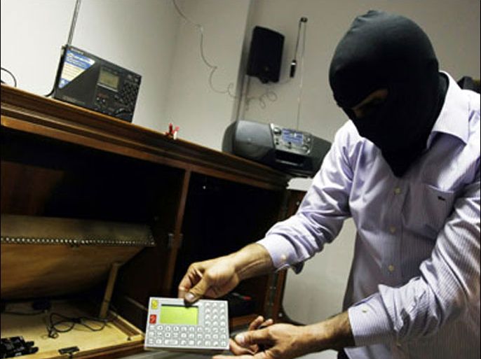 afp : A masked Lebanese secret service officer shows to the media at the Lebanese security services headquarters in Beirut on May 11, 2009 electronic devices found with