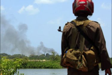 r : A Sri Lankan government soldier looks across to a trail of smoke coming from inside the 'No Fire Zone' near the town of Putumatalan, located in northern Sri Lanka, in this April 24,