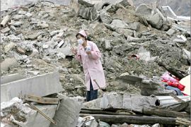 REUTERS / A nurse searches for survivors amid ruins of collapsed buildings in earthquake-hit Beichuan County, in Sichuan province, in this May 15, 2008 file photo.