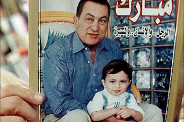 f_File picture taken on November 19, 1999 shows an Egyptian man holding a book on Egyptian President Hosni Mubarak's life at one of Cairo's bookshops with a picture