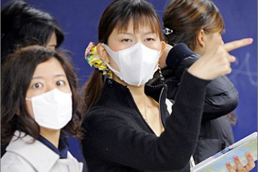 AFP - Two Asian tourists have their faces covered with surgical masks, as they try to find their way after emerging from a subway station in New York, May 04, 2009. The number of confirmed cases of swine flu in the United States continued to rise with US health authorities saying 286 people in 36
