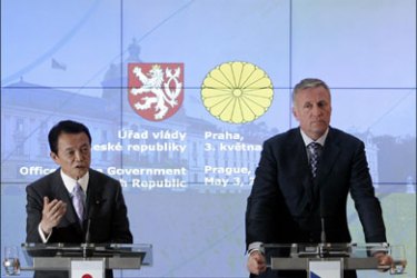 r : Czech Republic's outgoing Prime Minister Mirek Topolanek (R) and Japan's Prime Minister Taro Aso attend a news conference at the government headquarters in Prague