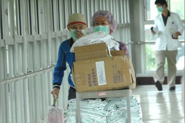 Medical workers push a trolley carrying protective clothing at a hospital in Taipei on May 21, 2009