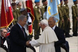 Pope Benedict XVI (C) shakes hands with Israeli Prime Minister Benjamin Netanyahu (L) next to President Shimon Peres (R) upon the pontiff’s’ arrival to Ben Gurion airport near Tel Aviv on May 11, 2009.