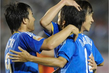 Japanese midfielder Kengo Nakamura (C) is conglaturated by his teammates Shinji Okazaki (L) and Shunsuke Nakamura (R) following his goal during the first half of the Kirin Cup football tournament in Tokyo