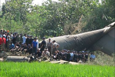 r_Rescue workers gather at the site of the wreckage of an Indonesian Air Force C-130 cargo plane after it crashed in Magetan in East Java province May 20, 2009
