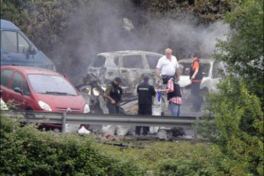 r : Police officers investigate the scene of a car bomb in Bilbao, June 19, 2009.