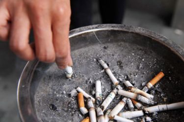 FINANCE-ECONOMY-HEALTH-SMOKINGA smoker stubbs out a cigarette outside a shopping mall in Hong Kong