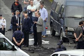 Spanish interior minister Alfredo Perez Rubalcaba (centre with beard) examines the scene of a car bomb in Bilbao, June 19, 2009. A bomb killed a police officer