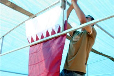 فلسطيني يثبت علم قطر خلال استقبال الوفد القطري في مخيم جباليا شمال غزة