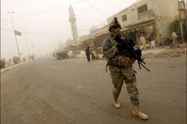 afp : US soldiers and Iraqi police take part in their last joint patrol in Khan Bani Saad, some 10 kms south of the town of Baquba, on June 28 2009, as a sandstorm engulfs this