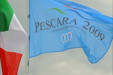 An Italian and the XVI Mediterranean Gams flag are pictured in Pescara on June 26, 2009. AFP PHOTO /