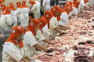 Employees work at a workshop of a pork processing factory in Chengdu, Sichuan province June 16, 2009. China, the world's largest pork producer