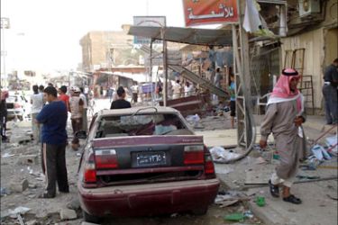 Iraqis survey the damage following a car bomb blast outside the offices of a Sunni Muslim Arab party in the western Iraqi city of Fallujah, 50 kms from Baghdad, on July 25, 2009.