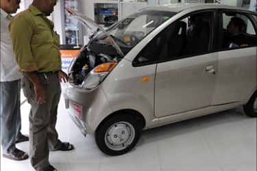 This picture taken on April 25, 2009 shows customers viewing the world's cheapest car Nano, build by Indian vehicle maker Tata Motors at a showroom in Mumbai