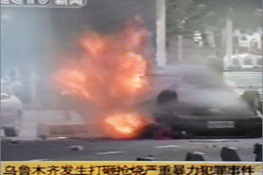 A frame grab of a television screen created on July 6, 2009 shows a broadcast by China Central Television (CCTV) in which an overturned police car burns on a street in Urumqi, the capital of China's Autonomous Region of Xinjiang on July 5, 2009.
