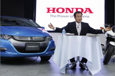 Honda Motor Co's chief executive Takanobu Ito speaks at a news conference between an Insight car (L) and a DN-01 motorcycle at a showroom in Tokyo July 13, 2009