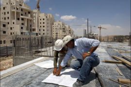r : Workers examine blueprints at a construction site in settlement near Jerusalem known to Israelis as Har Homa and to Palestinians as Jabal Abu Ghneim July 5, 2009.