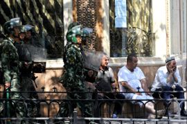 afp : Chinese riot police march pass local Uighur residents near a mosque just before Friday prayers in Urumqi, China's farwest Xinjiang region on July 10, 2009. Mosques in the