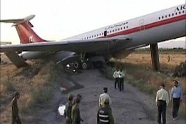 Officials look at the wreckage of a passenger airplane in Mashhad in this July 24, 2009 video grab. Seventeen people were killed when the aircraft caught fire while landing at the