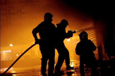 afp : Firemen spread water over a fire, during the night of July 9, 2009 and 10, in Firminy, central France, after clashes between police and youths, for the third consecutive night.