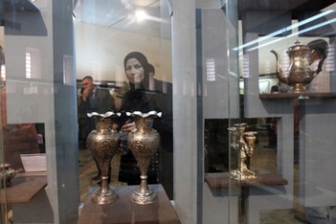 An Iraqi woman looks at silver ware on display at the National Museum formally belonging to the late General Abdel Karim Qassem during a two month exhibition of his personal