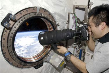 r : Japanese Aerospace Exploration Agency (JAXA) astronaut Koichi Wakata, Expedition 19/20 flight engineer, takes pictures out the forward Kibo or JEM window of the