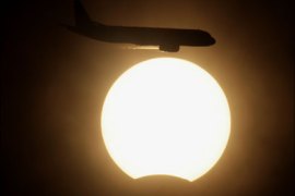 r - An aircraft flies pass the sun during a solar eclipse in New Delhi July 22, 2009. A total solar eclipse began its flight on Wednesday across a narrow path of Asia, where it was