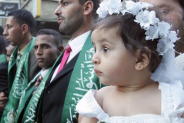 epa01805630 A little girl looks on as a total of 382 Palestinian youths wait during a mass wedding held by Hamas in the Yarmouk refugee camp in Damascus,
