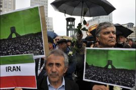 afp : Men holds up placards featuring a photo of mass protests in front of the Azadi Monument in Tehran during a rally to demand the release of political prisoners in Iran as