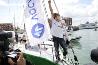 Mike Perham celebrates aboard his yacht "Totallymoney.com" after arriving at Gunwharf Quay in Portsmouth on August 29, 2009.