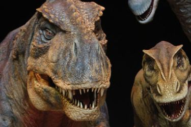 Actor Dominic Rickhards who plays "Huxley" the palaeontologist, poses with model dinosaurs on the set of the "Walking with Dinosaurs" show, during a media event
