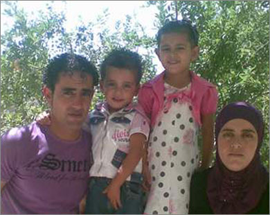 محمد (الثاني من اليسار) مع أسرته التي تعاني معه تداعيات مرضه النادر (الجزيرة نت)