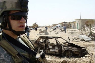 A U.S. soldier stands guard near the site of a car bomb attack in Shirqat, 300 km (190 miles) north of Baghdad August 29, 2009. A suicide car bomb exploded near a police station, killing