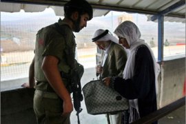 File picture dated September 5, 2008 shows an Israeli soldier checking the IDs of Palestinians heading to Jerusalem for Friday prayer at the Hawara checkpoint, outside the West Bank city of Nablus. In June Israel decided to remove checkpoints around Nablus as part of a plan for "economic peace" with the Palestinians