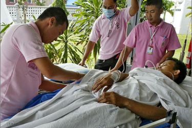 Thai hospital workers shift an injured Muslim rubber plantation worker from an ambulance to a hospital after he was allegedly shot at by separatist militants in Thailand's restive southern province of Narathiwat on August 25, 2009.